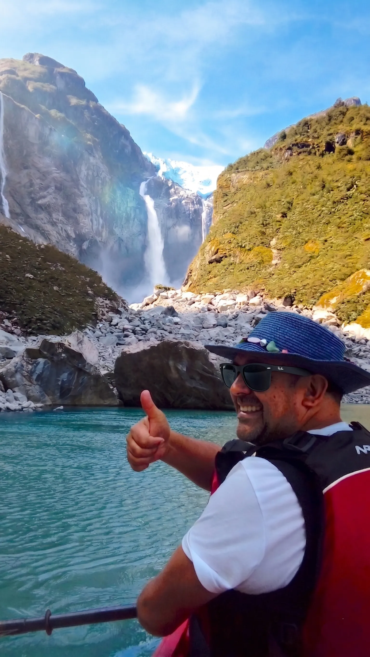 Pancho giving a thumbs-up from a boat before the hanging glacier and waterfall of Parque Nacional Queulat in Patagonia